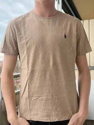 Ralph Lauren T-shirt - beige T-shirt från Ralph Lauren i mycket bra skick (endast använda vid några tillfällen) Storlek M Nypris~1000kr