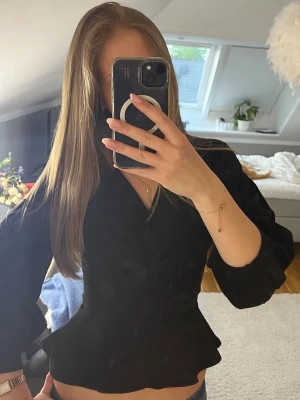 Svart blus med volangkant - Snygg svart blus med markerad midja och volangkant nertill💗💓 inte tydligt använd 