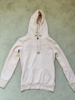 Superdry hoodie - Ljusrosa superdry hoodie. Använd några gånger. Väldigt bra skick. Inga skador.
