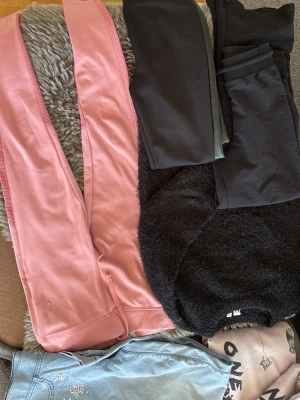 Svarta och rosa leggings - Säljer ett gäng leggings i olika färger, bland annat svarta och ljusrosa. De är tighta, stretchiga och har en enkel design utan synliga detaljer. Perfekta för en avslappnad och bekväm stil.