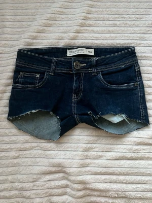 Lågmidjade jeansshorts  - Lågmidjade, mörkblåa jeanshorts i storlek 34, med midjemåttet 36cm