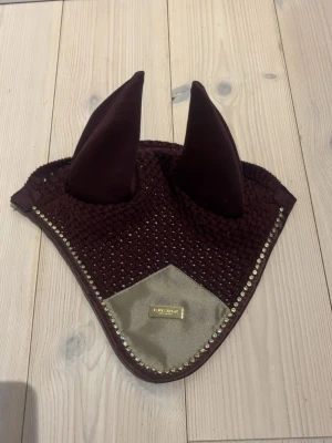 Equestrian Stockholm huva - Fin huva från Equestrian Stockholm i färgen crystal merlot gold storlek ponny! Endast använd två gånger så jättefint skick! Nypris 600kr, mitt pris 450kr eller bud.