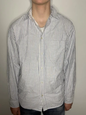 Randig vit och blå skjorta - Snygg vit&blå randig skjorta. Storleken är M. Hör av dig vid eventuella frågor! Vårat pris är inte hugget i sten🙃