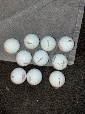 10 vita Titleist golfbollar - Säljer ett set med 10 vita golfbollar från Titleist. Perfekta för dig som vill fylla på golfbagen inför säsongen. Klassisk design med små röda och svarta detaljer samt numrering på varje boll.