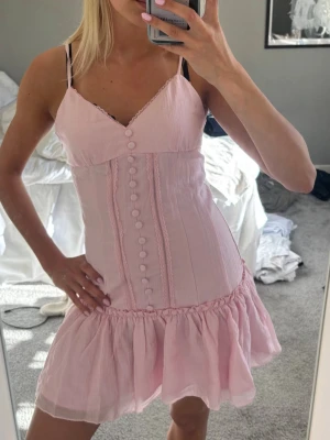 Rosa kortklänning med knappar - Söt rosa kortklänning med v-ringning och smala axelband från meet me there x Filippa💓helt slutsåld i denna storleken💓oanvänd med lapp kvar