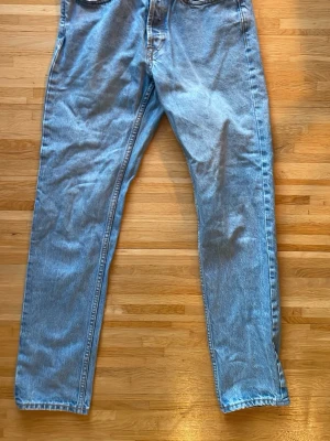 Ljusa blå jeans Regular 28/32 - Säljer ett par ljusa blå jeans med regular fit och raka ben. Modellen heter Regular Rigid och har klassisk femficksdesign. Jeansen är tillverkade i denim och har en enkel, tidlös look som passar till många olika stilar.