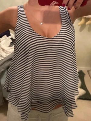 Randigt sommarlinne - Randigt, ”flowigt” linne med liknande som volanger nedtill, marinblå och vita ränder❣️