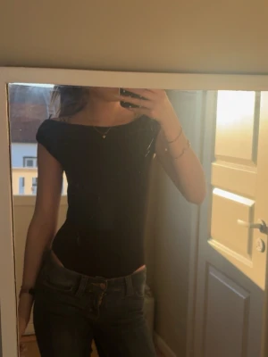 Svart body från Zara - Säljer en svart body från Zara i storlek S. Toppen har en tight passform och ärmlös design som ger en clean och stilren look. Perfekt att matcha med jeans eller kjol för en trendig outfit.