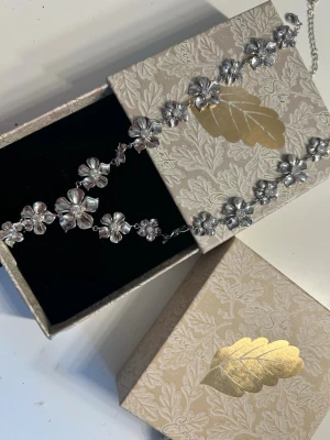 blomhalsband från IOAKU - Silver halsband från IOAKU, helt nytt, har inga defekter, säljer för de inte passar min stil 