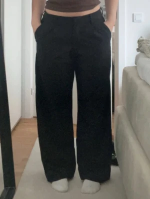 Svarta vida kostymbyxor - Säljer ett par svarta kostymbyxor med mellan midja och vida ben. Storlek S från Lager 157. Knappt använda💕