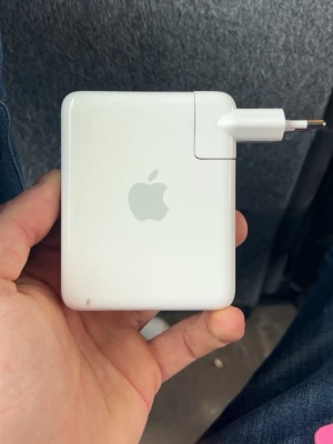 Apple MagSafe laddare 85W - Säljer en vit MagSafe-laddare från Apple på 85W, perfekt för MacBook. Klassisk fyrkantig design i plast med Apple-logga på framsidan och avtagbar stickkontakt. Smidig att ta med och enkel att använda till din laptop.