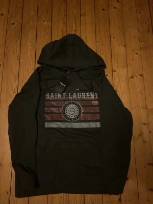 Saint Laurent hoodie  - Grå Saint Laurent hoodie i storlek L. Aldrig använd.  Den är f@k3 därav priset. Bara att höra av sig vid funderingar🤩