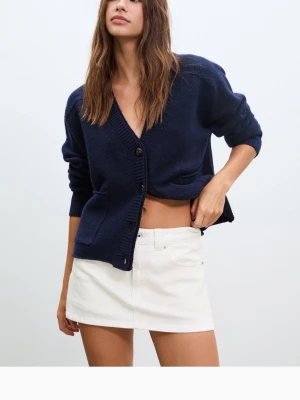 Vit kortkjol i bomull - Stilren vit kortkjol i mjuk bomull med klassisk femficksdesign och raka linjer. Kjolen har en enkel look som passar perfekt till en avslappnad eller trendig outfit. Lätt att matcha med olika toppar och accessoarer.