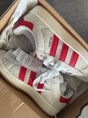 Campus 0Os "Crystal WhiteBetter Scarlet" - Säljer dessa Adidas Campus 0Os "Crystal White Better Scarlet". Vita skosnören och extra röda skosnören medföljer. Storlek 38 2/3. Aldrig anvanda, bara testade & lappen sitter kvar (köpta för 1999kr) 🩷skicka gärna pris förslag