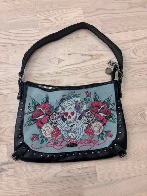 Ed Hardy🖤 - Snygg handväska Ed Hardy. Köpt i LA. Den är ca 30 cm x 43 cm. Helt ny!