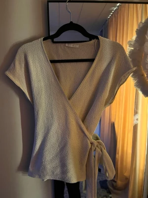 Beige omlottopp från Zara - Snygg beige omlottopp från Zara som är helt slutsåld! Knappt använd🩷Toppen är i Stl M men är liten i storleken så passar även S