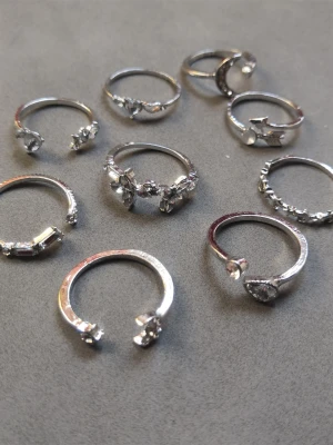 9-pack ringar  - 9 st ringar med olika former och mönster. Materialet är alloy. (#602)
