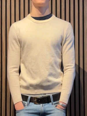 These glory days  - Klassisk beige stickad tröja med rund hals och långa ärmar. Tröjan har en enkel och stilren design utan synliga loggor eller mönster, vilket gör den lätt att matcha. Tillverkad i mjukt material som ger en skön känsla. Perfekt till jeans eller chinos.