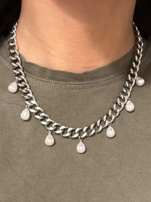 Silvrigt 9mm bred halsband med pärlor  - Finns även i guldpläterad variant. Matchande örhängen finns i en separat annons   Material: Rostfritt stål och ABS (Acrylonitrile Butadiene Styrene) på pärlimitationen  Bredd: 9 mm Längd: 38–43 cm Nickelfria och handgjorda. Märke: Diavansa smycken 