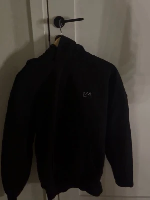 Svart Hov1 hoodie med tryck - Svart hoodie från Hov1 med liten krona broderad på bröstet och stort vitt turnétryck på ryggen med texten 'Vi Dansar Vidare I Livet'. Aldrig använd🩵
