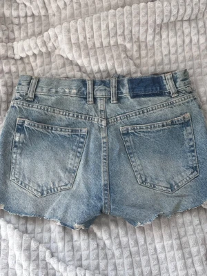Midwaist Jeansshorts från Zara - Blå-gröna jeansshorts från Zara. Rätt så hög i midjan och knappar istället för "vanlig" gylf. Använd max 2-3 gånger.
