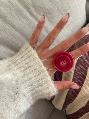 Ring med knapp - Säljer denna handgjorda ring.  Knapparna är vintage men själva ringen/ringstommen är helt ny och oanvänd. Materialet är rostfritt stål och varken tappar färg eller färgar av sig på huden. Ringen tål vatten. Storleken är justerbar, man kan trycka ihop och dra isär ringen till önskad storlek. Perfekt för dig som vill bära något unikt!
