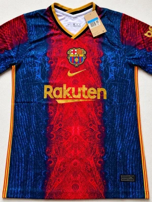 FC Barcelona matchtröja Nike blå/röd - Säljer en FC Barcelona matchtröja från Nike i blått och rött med guldiga detaljer. Tröjan har klubbmärke, Rakuten och UNICEF-logga samt gula ränder längs sidorna. Tillverkad i lätt och ventilerande polyester, perfekt för fotbollsträning eller match.
