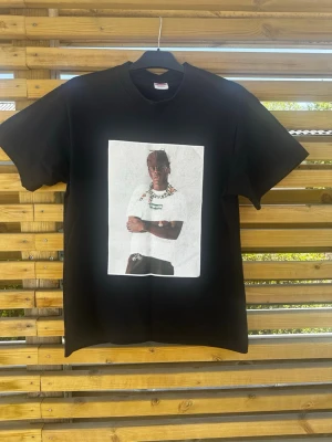 Svart supreme t-shirt med tylerthecreator tryck - Svart supreme t-shirt med ett stort tryck av tylerthecreator på bröstet. Klassisk passform och rund halsringning. Perfekt för dig som gillar streetwear och vill ha en unik look. Materialet känns mjukt och bekvämt mot huden.