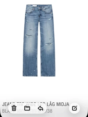 Baggy jeans med hål från Zara  - Trendiga blå jeans med låg midja,  wide leg-passform och hål/slittningar. Från Zara i storlek 38. 