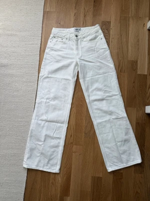 Vita vida jeans från lager 157  - Säljer ett par vita optiwide jeans från lager 157 i storlek XS. Jeansen har klassisk femficksdesign, hög midja och patch i läderimitation bak. Perfekta för en clean och fräsch look. Materialet är bomull med denimstruktur. Säljer för dom är för långa på mig🤗