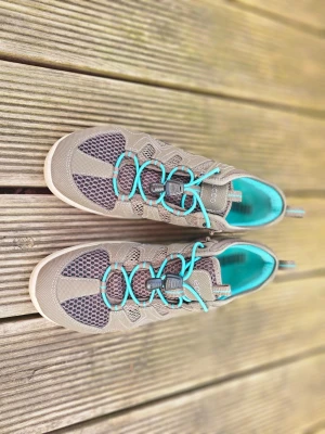 ECCO sneakers med turkosa detaljer - Säljer ett par ECCO sneakers i beige och grå mesh med turkosa snören och innerfoder. Skorna har sportig design, ventilerande meshpaneler och praktisk snabbsnörning. Perfekt för dig som gillar en aktiv livsstil och vill ha snygga, bekväma skor.
