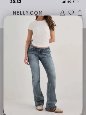 Blå bootcut jeans från Nelly - Snygga blå bootcut jeans från Nelly med klassisk femficksdesign och låg midja. Jeansen har en lätt tvättad look och utsvängda ben, perfekta för en avslappnad och trendig stil. Tillverkade i denim med stretch för extra komfort.