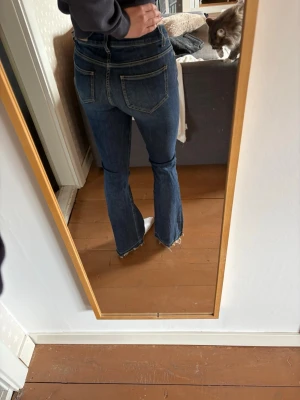 Blå bootcut jeans  - Designen på de är uppsprett längst ner vilket ser coolt ut med färgen.