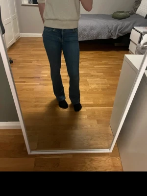 Blå low flare jeans XS längd 31 - Säljer ett par blå low flare jeans i storlek XS och längd 31. Jeansen har klassisk femficksdesign, låg midja och utsvängda ben. Perfekta för dig som gillar en trendig och avslappnad look.