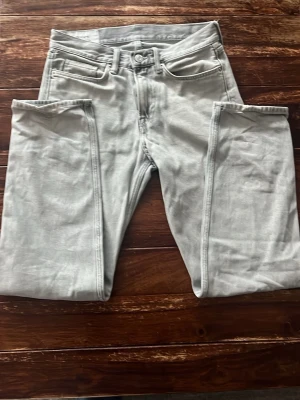 Ljusgrå straight relaxed fit jeans från H&M - Säljer ett par ljusgrå jeans med straight relaxed fit. Jeansen har klassisk femficksdesign och raka ben. Perfekta för en chill och avslappnad stil. Storlek 29/32. Lite mer baggy än typiska regular jeans.