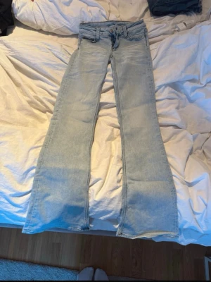 Ljusblå bootcut jeans från Cheap Monday - Säljer ett par ljusblå bootcut jeans från Cheap Monday med klassisk femficksdesign och låg midja. Jeansen har en snygg tvättad look och är tillverkade i denim med stretch. Perfekta för dig som gillar retrostil och vill ha ett par bekväma jeans med lite vidare ben.