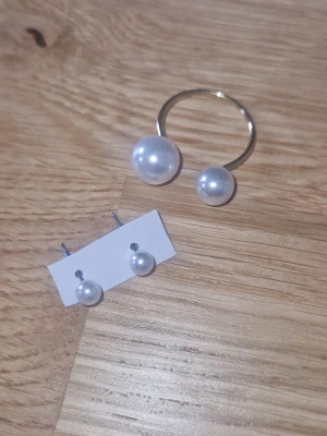 Smyckesset - Ett par stilrena pärl örhängen med matchande ring. Klassisk rund form som passar till många olika stilar. Perfekta för dig som gillar enkel men elegant design.