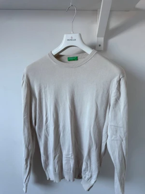Beige rundhalsad tröja Benetton - Klassisk beige tröja från Benetton Tillverkad i ett tunt, mjukt material som passar perfekt för lager på lager och en clean look.