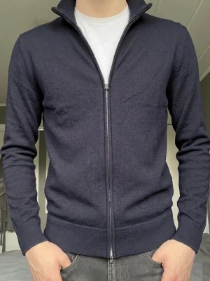Oanvänd mörkblå fullzip These Glory Days - Mörkblå fullzip från These Glory Days i nyskick med lappen kvar. Säljer då jag inte haft användning av den. Storlek M men passar även S 175-185 cm lång. Köpt på Volt för 1099. Hör av dig vid frågor!
