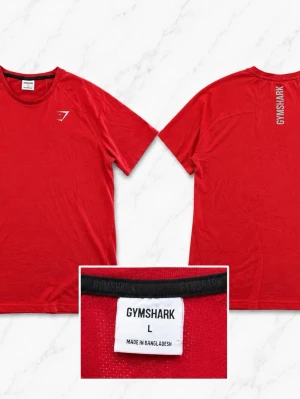 Röd Gymshark t-shirt  - Snygg röd t-shirt från Gymshark med logga på bröstet och tryckt text i nacken. Klassisk rund halsringning och korta ärmar. Perfekt för en sportig och avslappnad stil. Tillverkad i mjuk bomull för skön komfort.