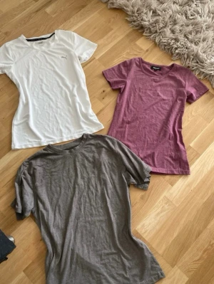 Träningströjor -strl S - Tre stilrena träningströjor: en vit från Puma med diskret logga, en lila/rosa från Only och en grå basic t-shirt. Alla har rund halsringning och korta ärmar. Perfekta för ett träningspass 