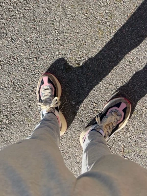 Gucci Rhyton sneakers rosa och svart - Säljer ett par Gucci Rhyton sneakers i en unik färgkombo med rosa, svart och beige detaljer. Skorna har chunky sula, klassiska snörningar och Guccis logga på plösen. Materialet är en mix av läder och textil, perfekt för dig som vill sticka ut med din stil.