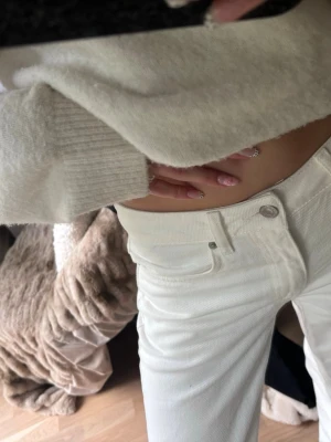 Vita raka jeans från 157 - Säljer ett par vita jeans från 157 med raka ben och klassisk femficksmodell. Jeansen har silverfärgade nitar och knapp, samt bälteshällor. Perfekta för en fräsch och stilren look.