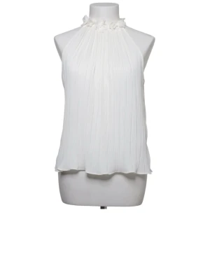 Vit halterneck blus - Snygg vit plisserad blus med halterneck och dekorativa volanger vid halsen. Luftig och ärmlös modell som ger en elegant känsla. Perfekt att styla med både jeans och kjol för en trendig look.