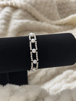  pärlarmband i silverfärg - Fin armband med små silverfärgade kulor och vita pärlor. Elastiskt band gör det enkelt att ta på och av och bra stretch i