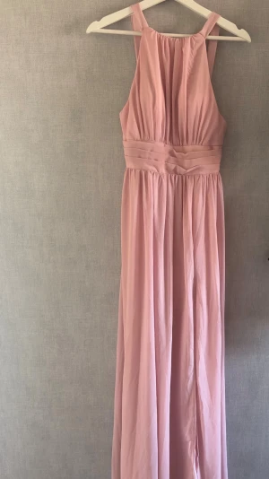 Ny med prislapp Ljusrosa långklänning  - Elegant ljusrosa långklänning med vackert fall. Klänningen har markerad midja och lätt rynkad överdel. Perfekt för speciella tillfällen som bal, bröllop eller sommarfester, 🌸 ny med prislapp kvar 