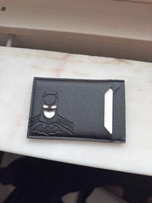  Batman plånbok - Snyggt svart kortfodral i läder med Batman-motiv präglat på framsidan. Med ett körkort ser det ut som att man är batman!