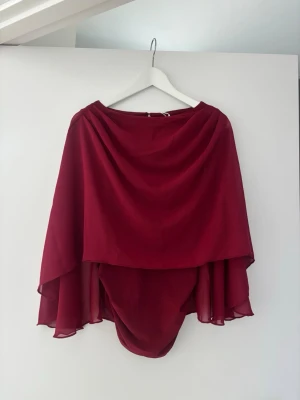 Vinröd omlott blus med öppen rygg - Snygg vinröd blus i omlottmodell med flowiga ärmar och öppen rygg från Nakd. Storlek S. Prislapp sitter kvar och nypris 499❤️🌶️