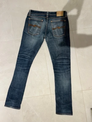 Blå Nudie jeans - Säljer nu mina riktigt snygga Nudie jeans med riktigt feta fades. Storlek W32 L32. Hör av dig vid minsta fråga 👍