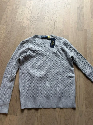 Grå Polo Ralph Lauren Tröja - Hej säljer min Ralph lauren tröja som jag hittade i min garderob, helt ny. Säljer billigt, rensar min garderob. Hör av gärna. 